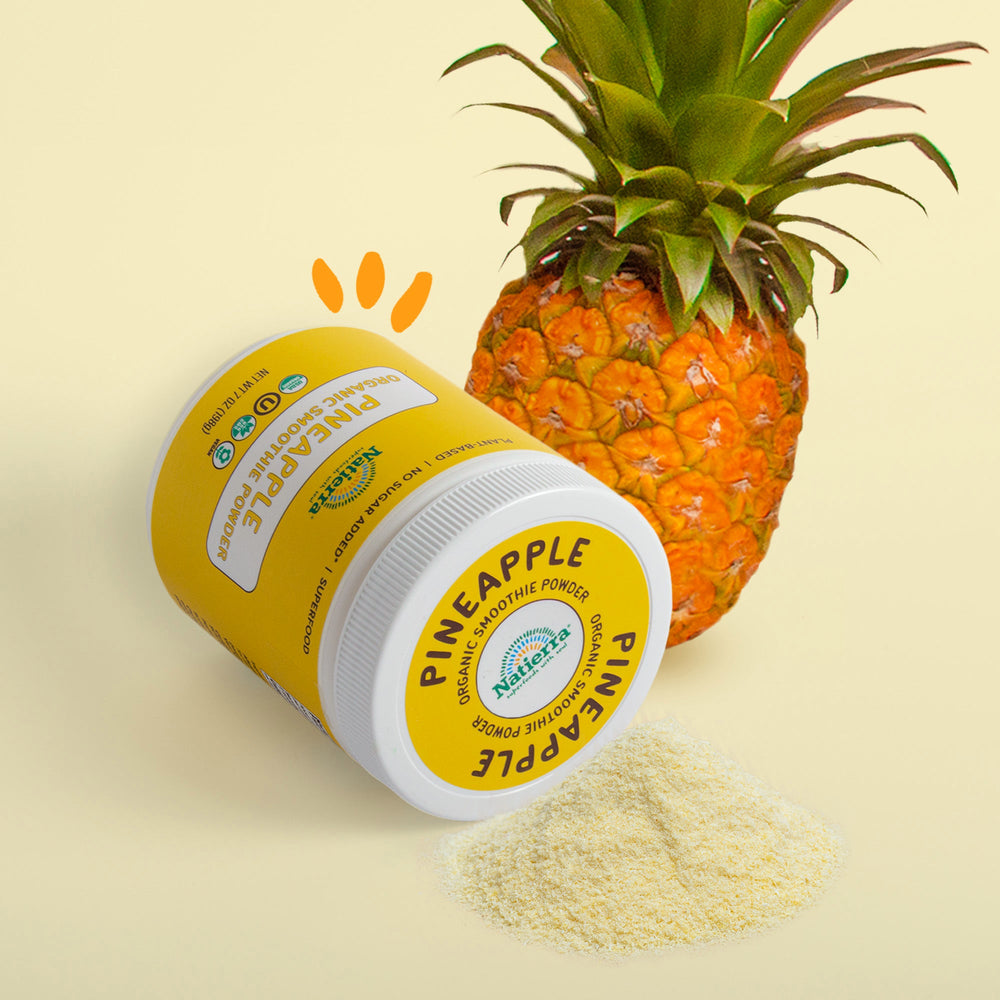 Pineapple smoothie jar next to a fresh pineapple