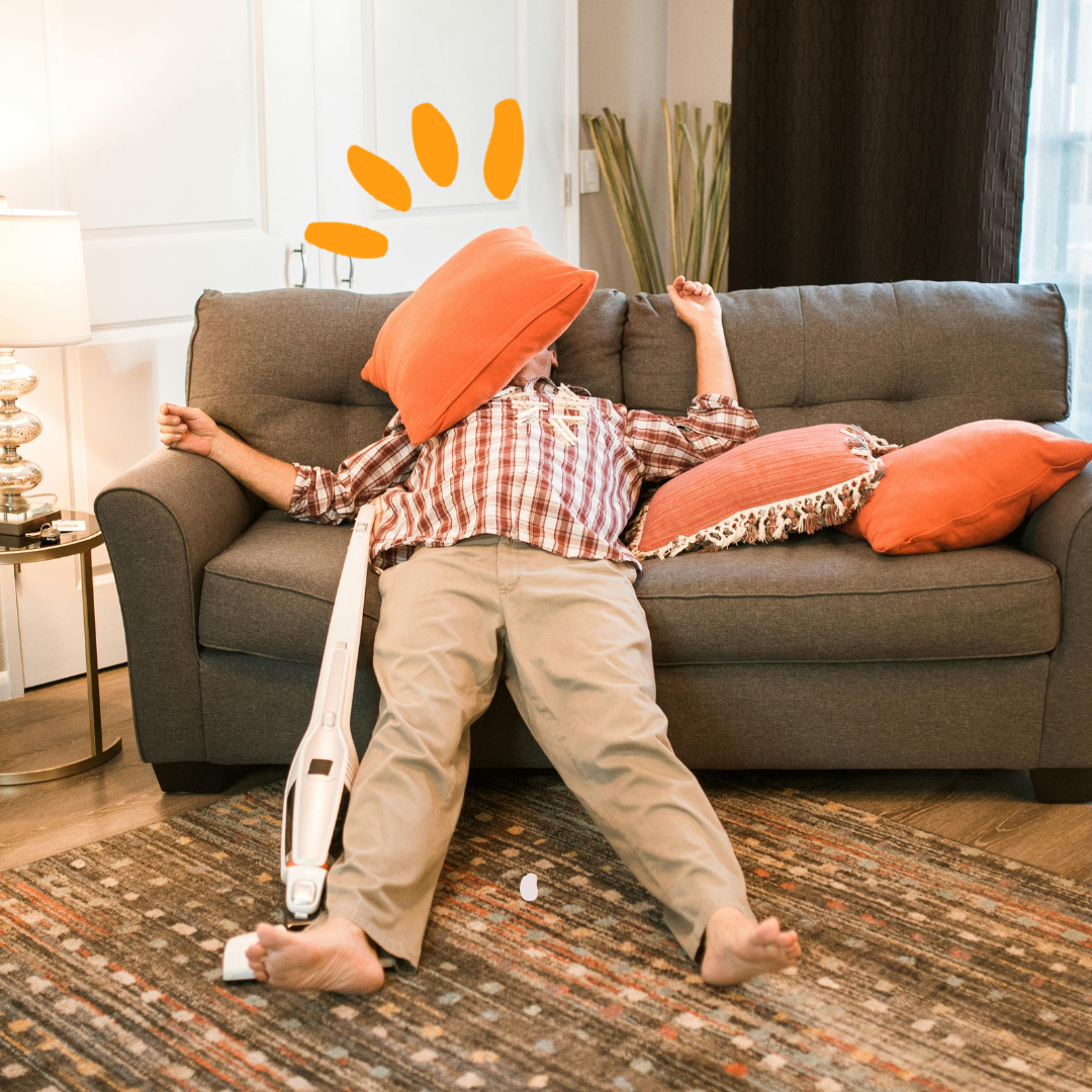 a person lying on a couch with a vacum next to him
