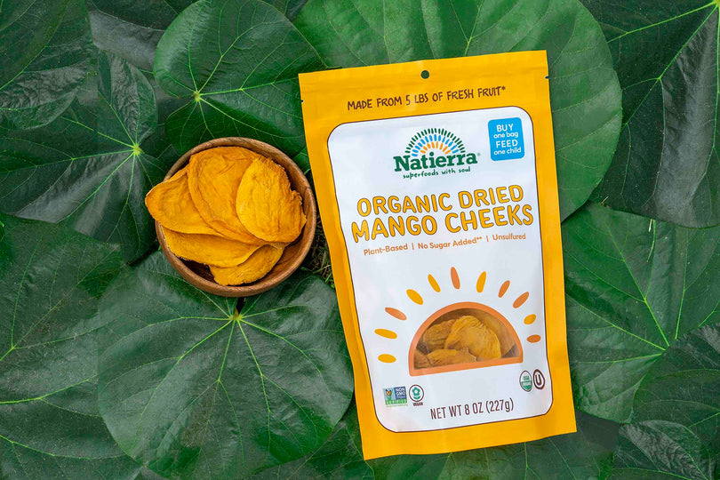 Bag of organic dried mango cheeks on a bed of green leaves