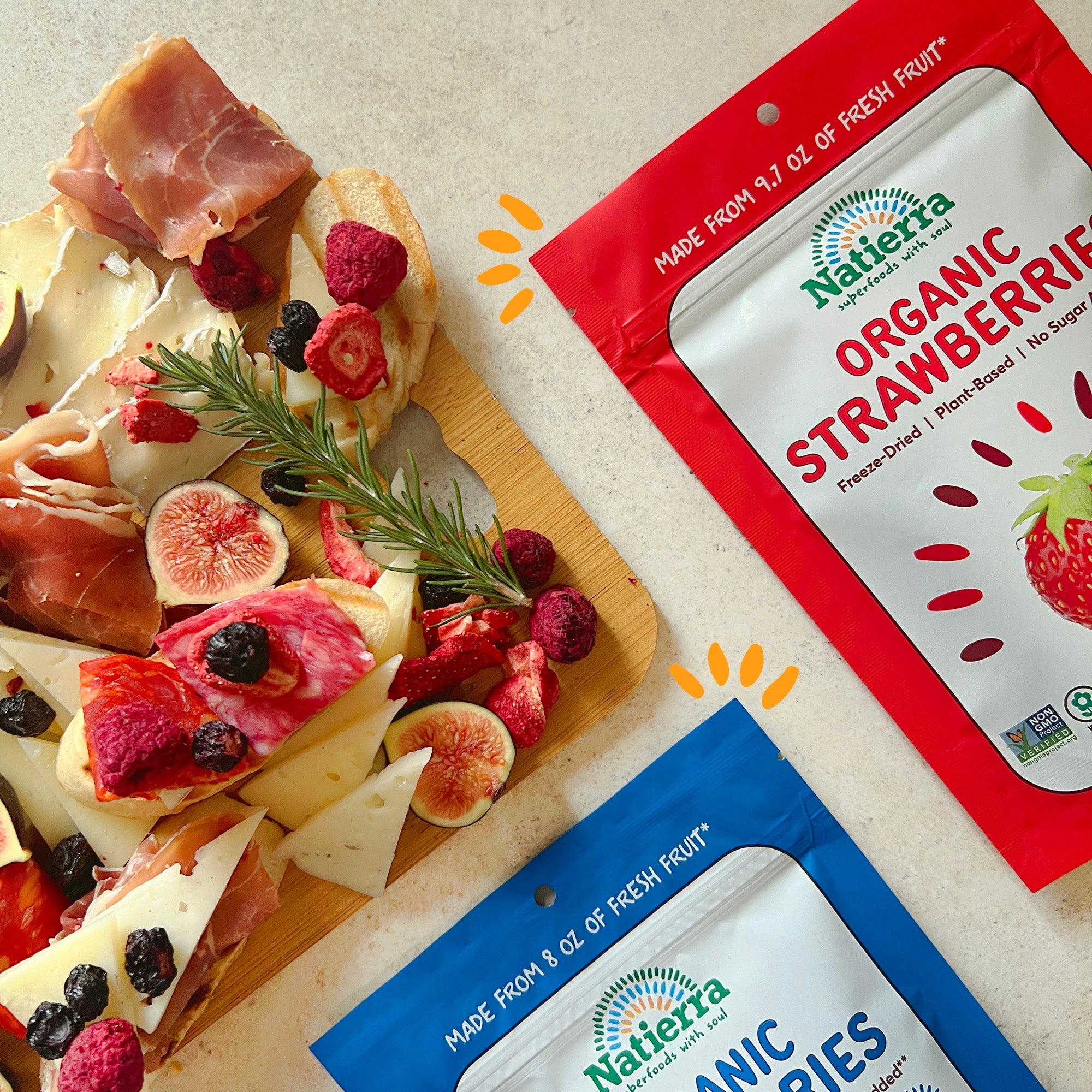 charcuterie board next to bags of organic strawberries and blueberries