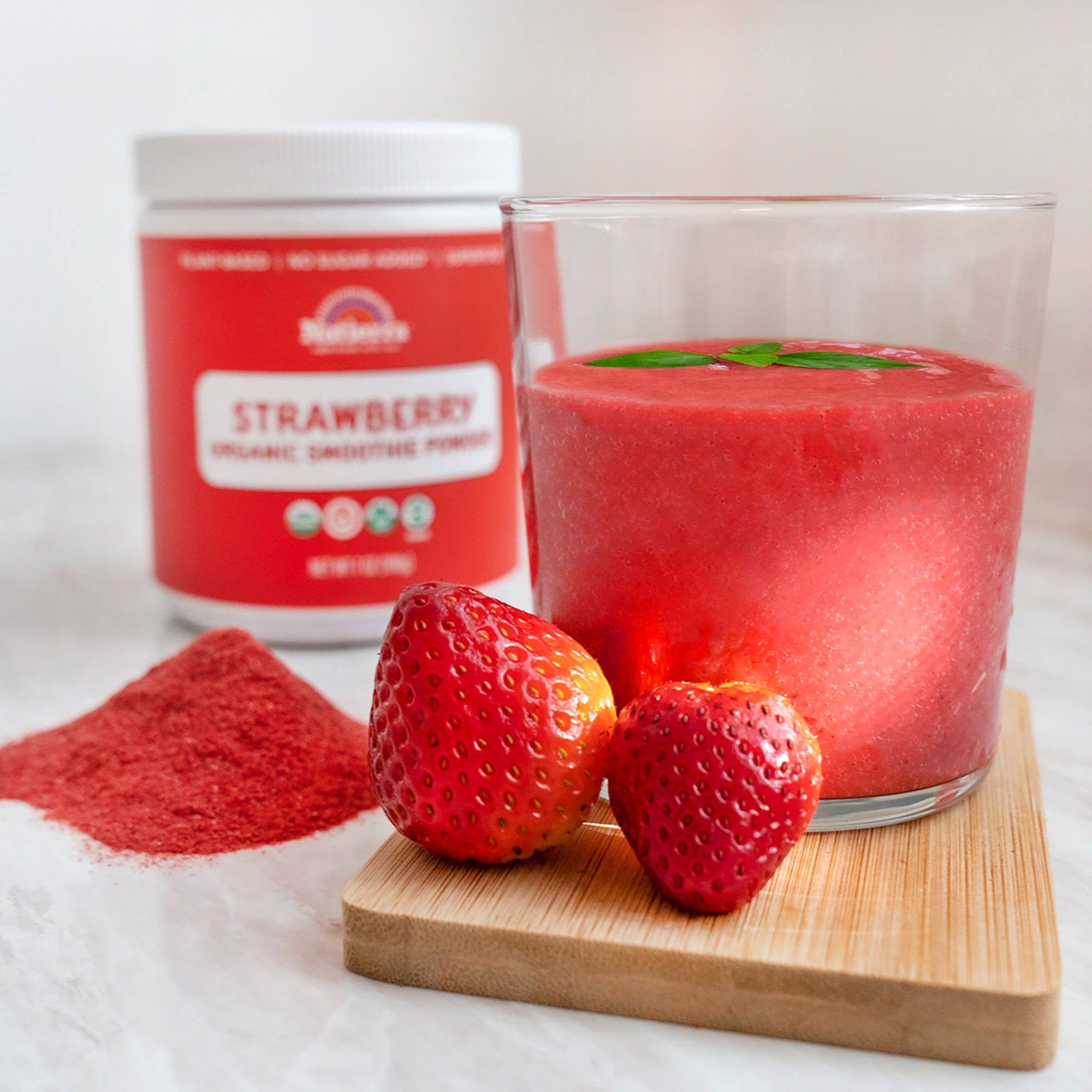 Strawberry smoothie in a glass and the jar in the back