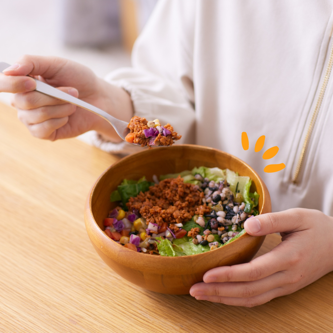 Person eating a bowl of grains and veggies