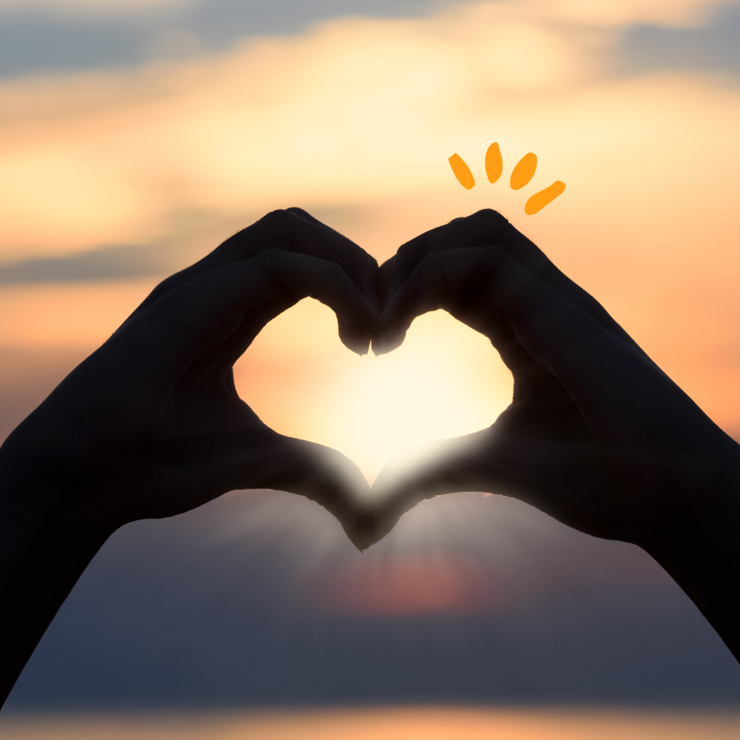 Two hands in the shape of a heart with background light