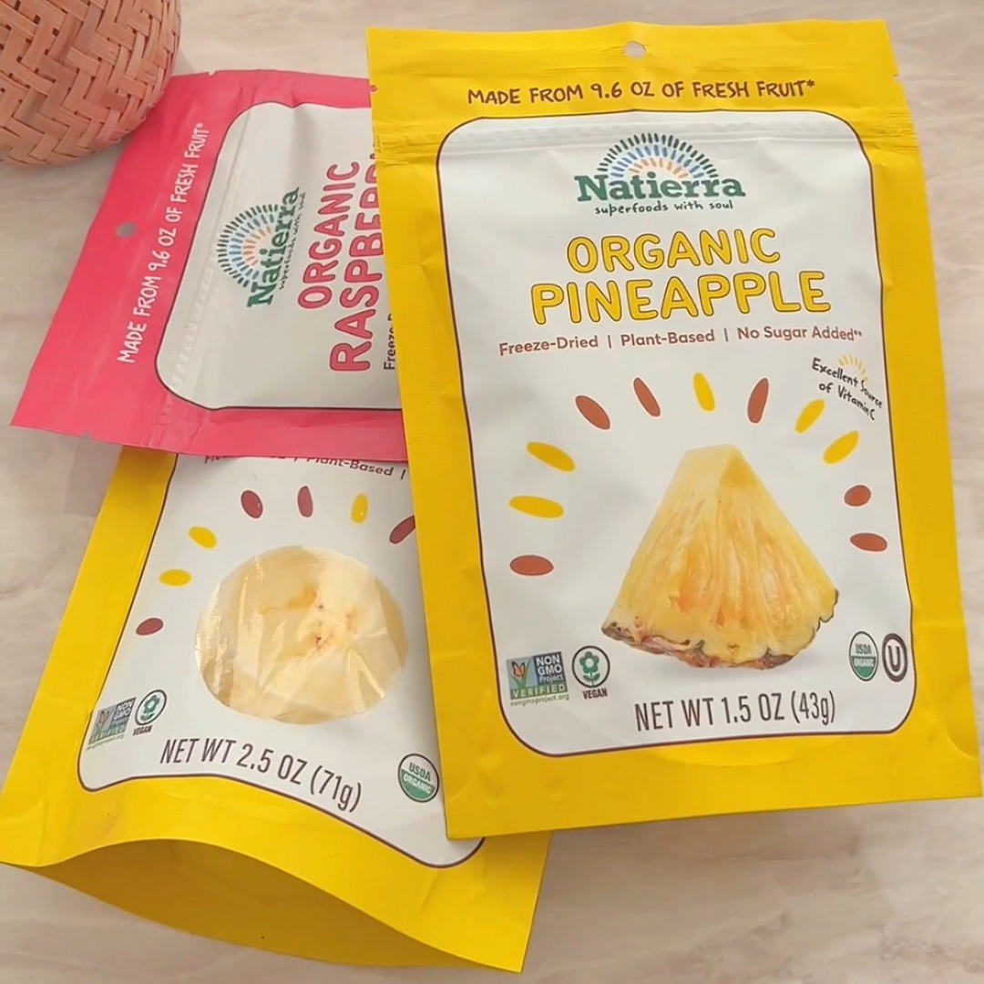 Pile of three bags of organic pineapple, raspberries and bananas freeze-dried fruits