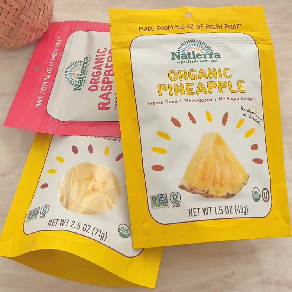 Pile of three bags of organic pineapple, raspberries and bananas freeze-dried fruits