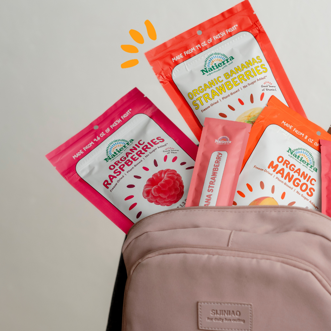 Organic freeze-dried snack bags and smoothie packets inside a backpack