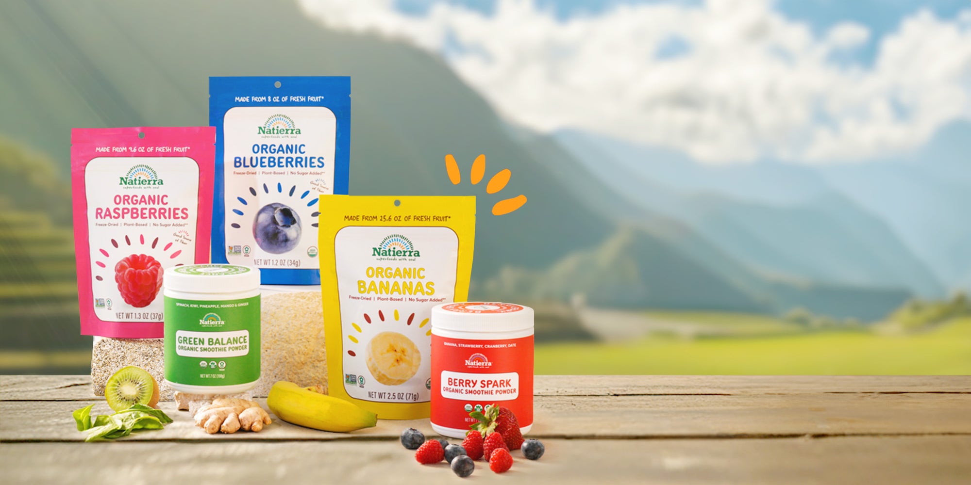 Natierra products displayed with fruits and vegetables with mountains in the background