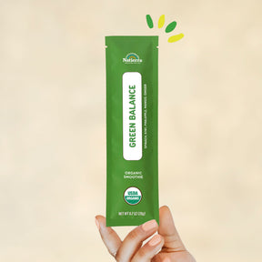 Individual stick pack of Natierra's Green Balance Organic Smoothie held by a hand in front of a creme background thumbnail
